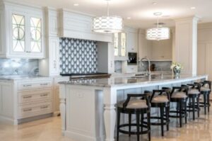A stylish, newly remodeled kitchen with white cabinets and black bar stools